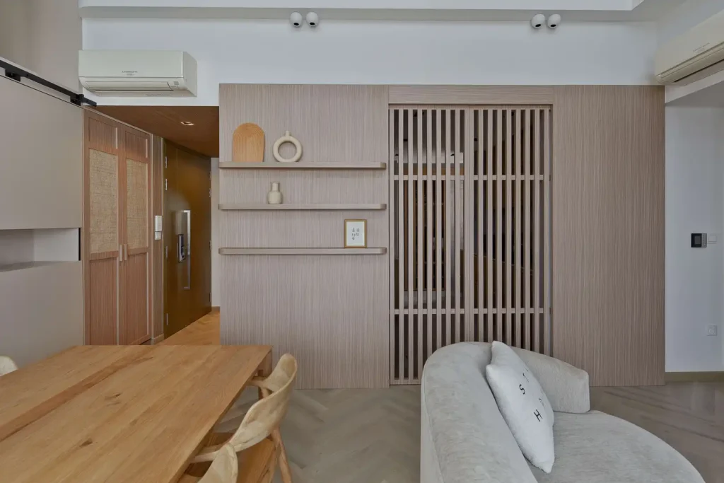 Japandi dining area with wood table, slatted partition and minimalist shelves in KL home