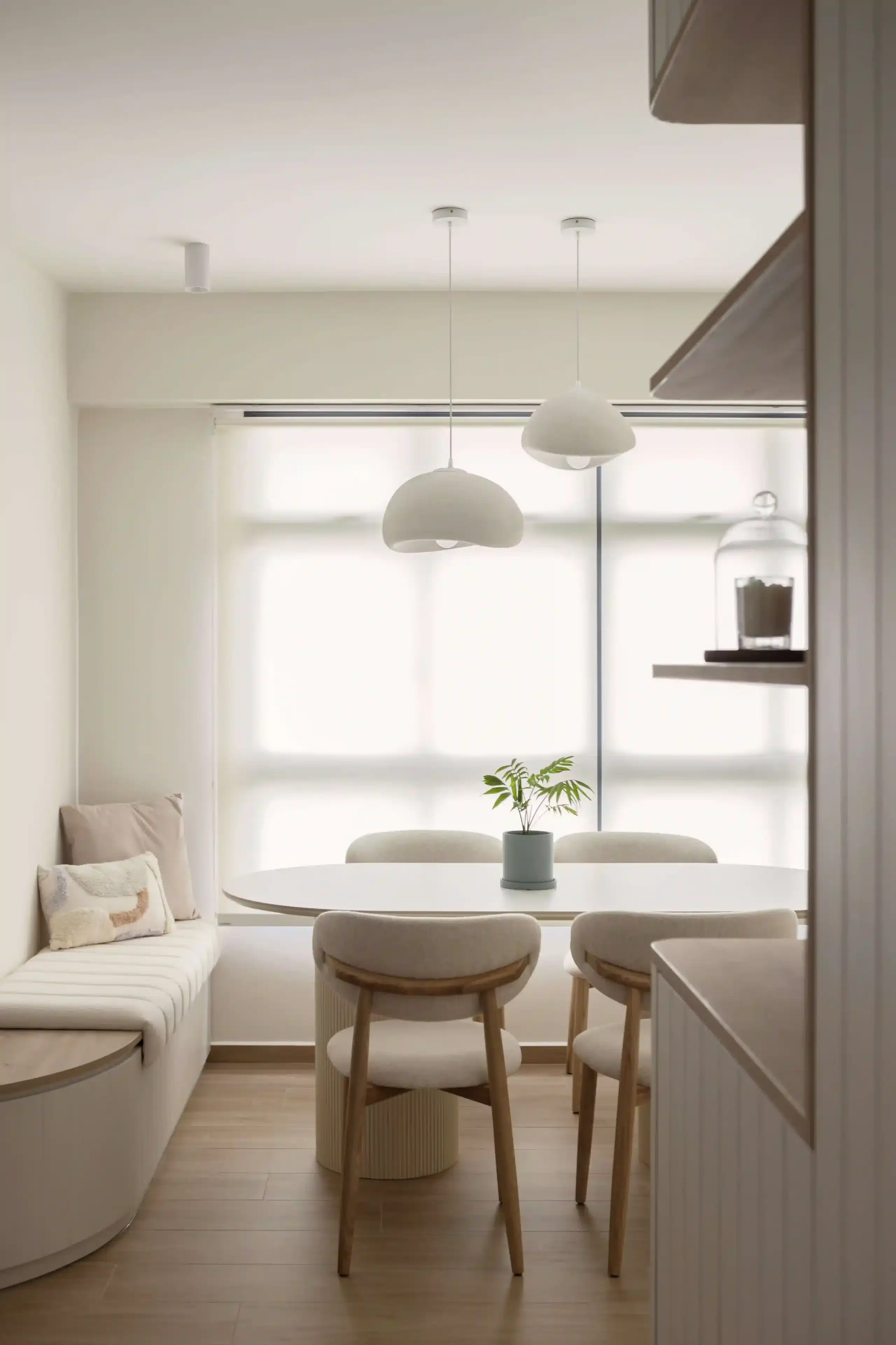 Minimalist interior design dining room with curved banquette, timber chairs and diffused natural light