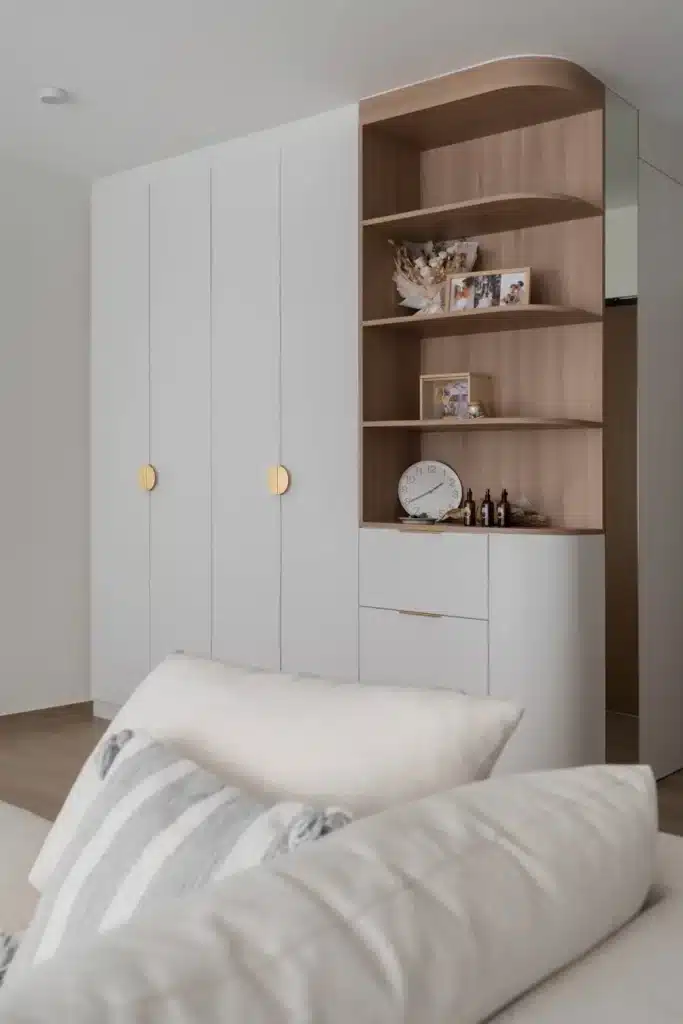 minimalist bedroom with curved wardrobe and light wood finishes in Kuala Lumpur