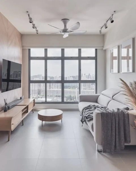 Small sitting room design maximizing natural light with chevron feature wall, wall-mounted TV and raised-leg furniture.