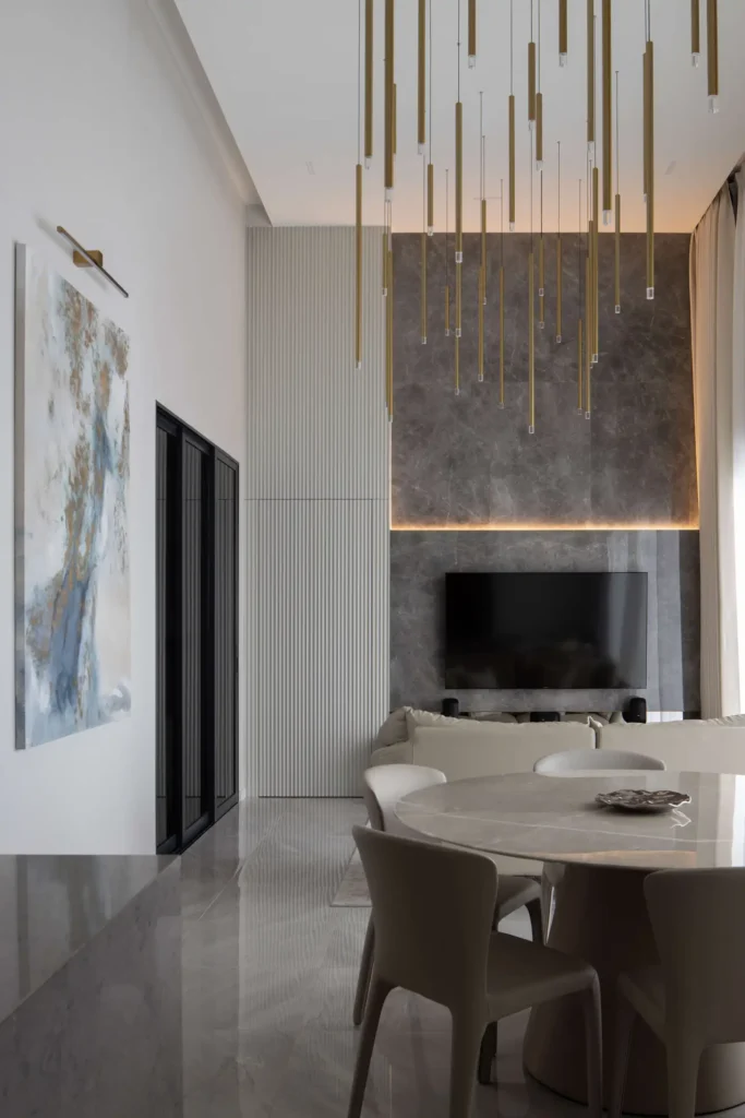 Modern luxury living room with double-volume ceiling, statement lighting and marble TV wall by Lemonfridge Studio in Kuala Lumpur.